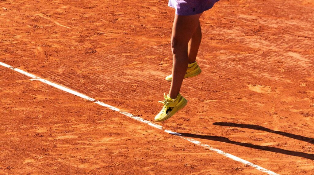 Joueuse en chaussures de tennis sur un court en terre battue