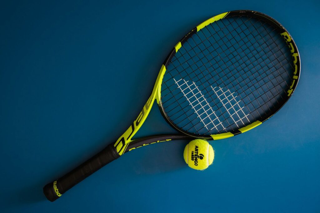 Raquette de tennis Babolat et balle sur un court bleu
